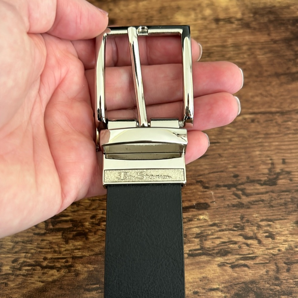 Black synthetic leather. Silver buckle. Stamped size: small 30-32 inches